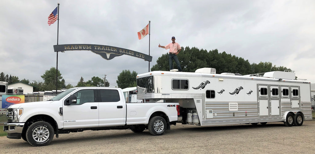Magnum white pickup pulling a 4 horse living quarters trailer
